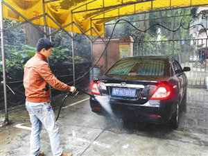 在莲花北的一家洗车店，洗车工正在使用耗水量较大的水枪洗车。深圳晚报记者 李珣 摄